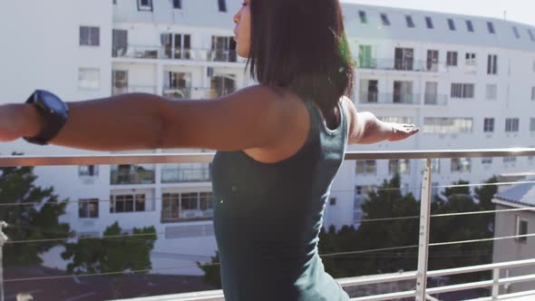 Mixed race gender fluid person practicing yoga meditation on roof terrace