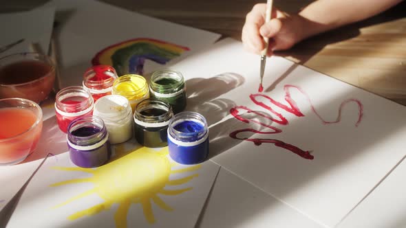 Boy Draws a with Watercolor Paints and Brushes Children's Creativity