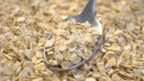 Cereal oatmeal flakes with spoon. Crushed raw breakfast porridge. Organic product. Macro