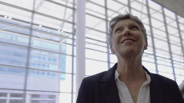 Businesswoman looking upwards in the lobby at office 4k