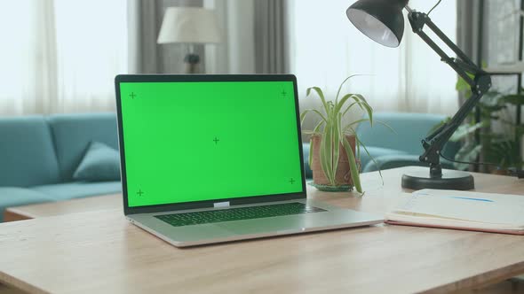 Laptop Computer Showing Green Key Screen Stands On A Desk In The Living Room