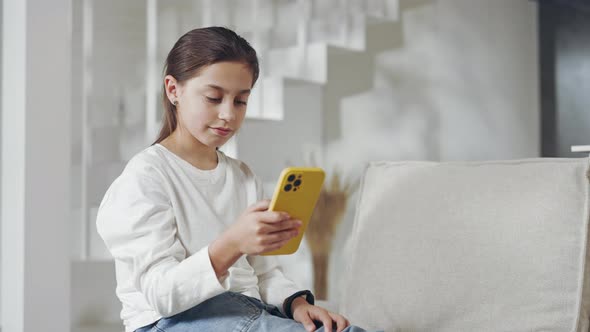 Cheerful Female Teenager Reading Great News on Mobile