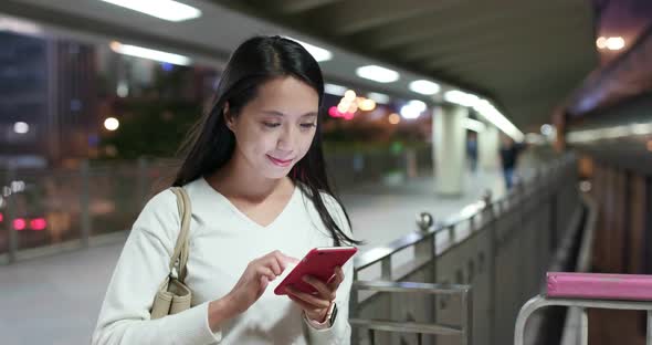 Woman use of mobile phone at business district at night