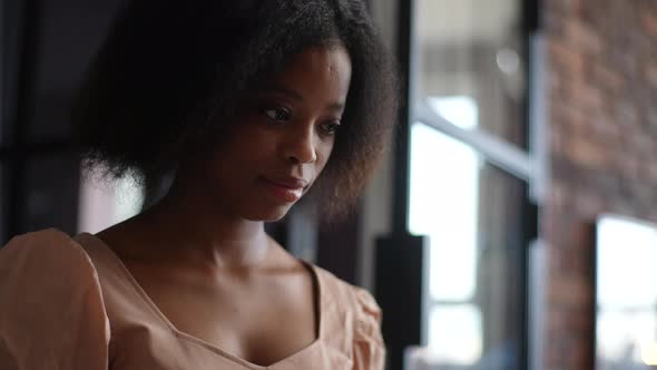 Closeup Face of Pretty AfricanAmerican Freelancer Working Online Looking at Laptop Screen and Typing