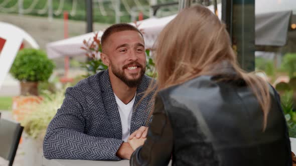 a Couple is Sitting at a Table in an Outdoor Cafe