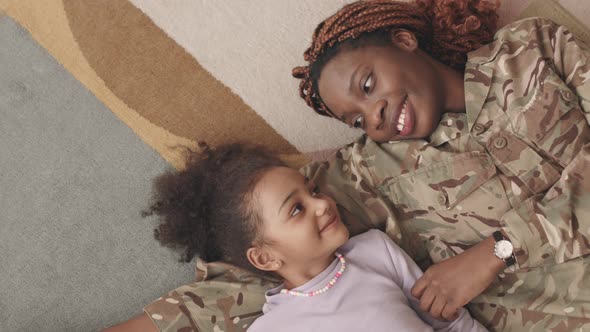 Affectionate Mother and Daughter Lying on Floor Embracing alt