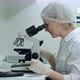Scientist Working with Microscope, Calculating and Taking Notes in Laboratory - VideoHive Item for Sale