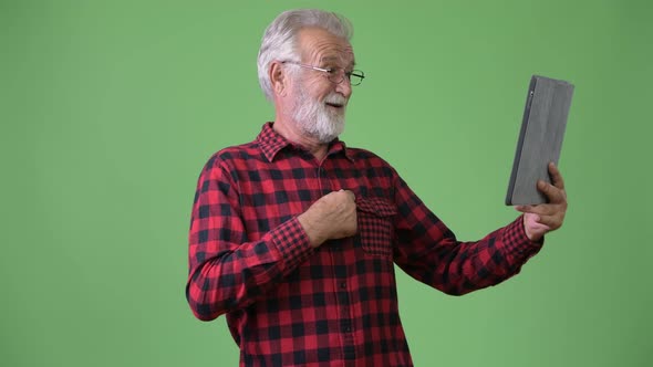 Handsome Senior Bearded Man Against Green Background