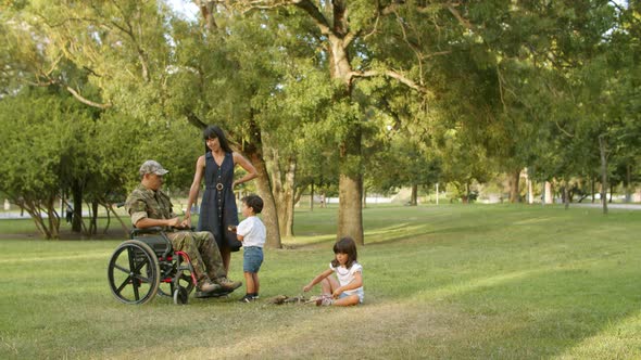 Two Sibling Children Enjoying Leisure Time with Handicapped Dad