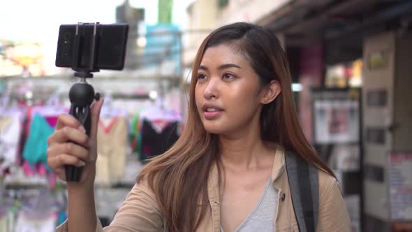 Young Female Tourist Holding a Gimbal with Smartphone and Recording Videos
