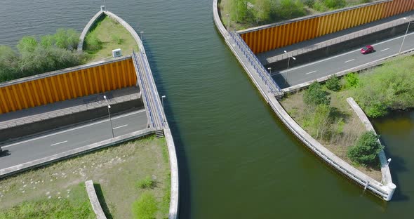 Aquaduct Veluwemeer water bridge with boat crossing above highway traffic, Aerial view.