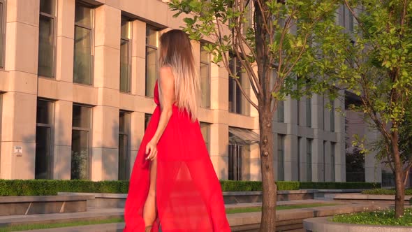 Beautiful Young Girl Dancing on the Street of a Modern Building of a Business Center in the Sunset