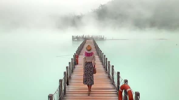 Timelapse Video of a Woman Standing on a Bridge on a Stunning Blue Volcanic Lake