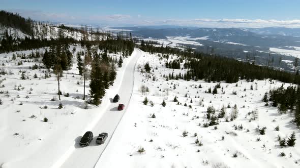 Aerial View of Car Moving By Snowed Road in Mountains