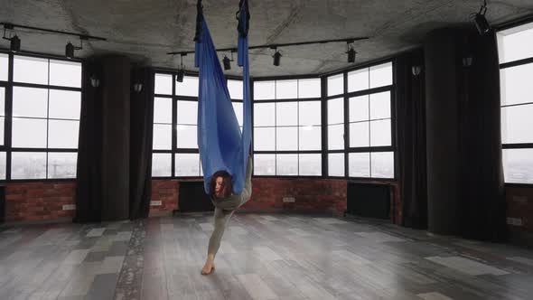 Woman Practicing Fly Yoga in Loft Studio