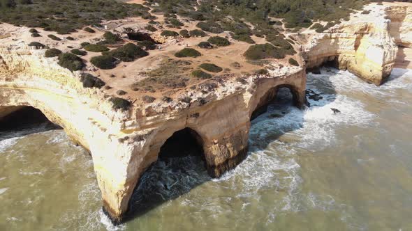 4k drone footage circling a unique rock formation found along the shoreline of Benagil, Portugal