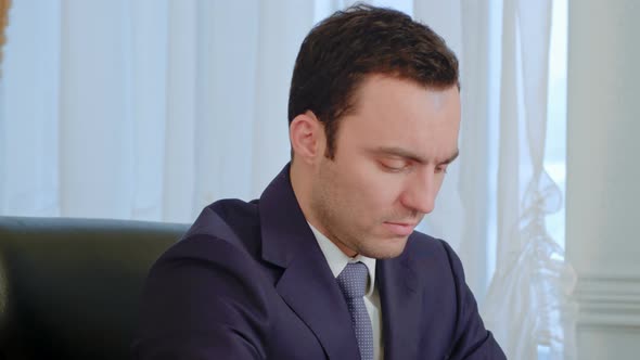 Tired Businessman Concentrated on Work and Yawning in the Office