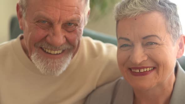 Closeup Portrait of a Mature Grayhaired Couple Husband and Wife Laughing While Looking at the Camera