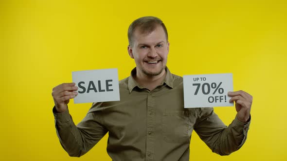 Cheerful Man Showing Sale Word and Showing Up To 70 Percent Off Inscription. Black Friday Concept