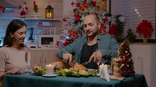 Couple Eating Chicken at Festive Dinner on Christmas Eve