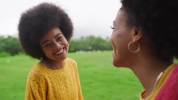Two mixed race women laughing in park