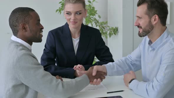 Mixed Race Business People Shaking Hands in Office