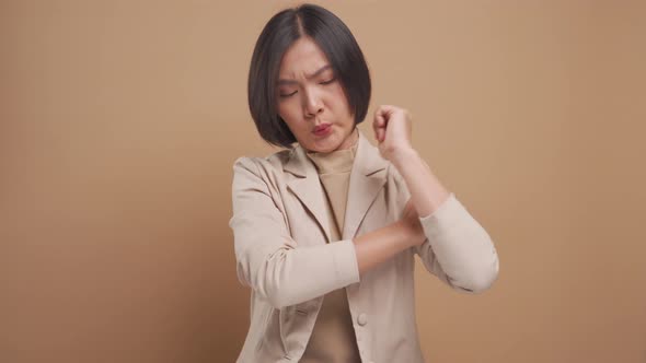 Asian business woman was sick with body pain and standing isolated over beige background. 4K video
