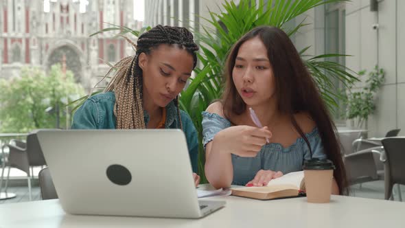 Happy Asian or African American Girls University Students Doing Study Research Looking Screen Laptop