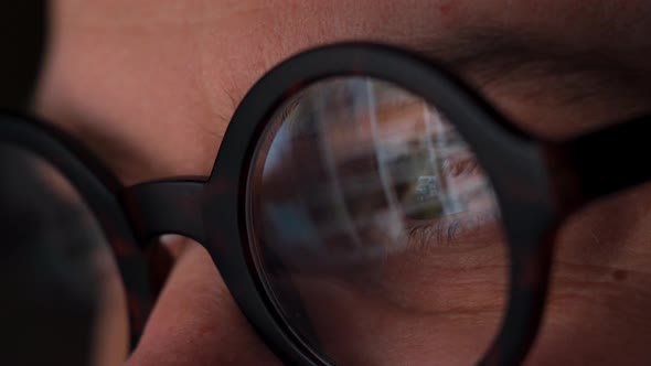 Man in Glasses Looking on the Monitor and Surfing Internet