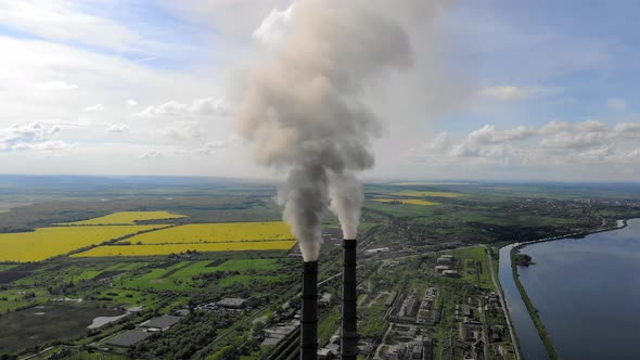 Aerial View Environmental Pollution. Two Tall Pipes That Emit Black Smoke Into the Atmosphere