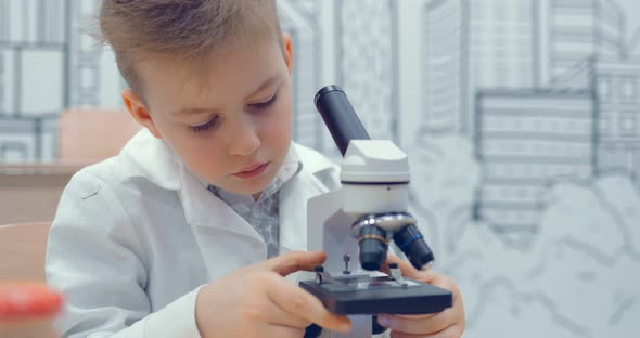 Children is Looking Through a Microscope