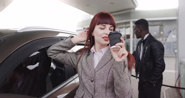 Handsome Smiling African Man Fueling Luxury Car at Petrol Station While Woman