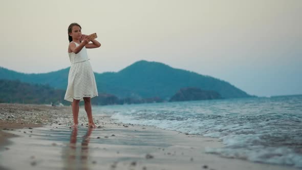 Young Girl Taking Selfie Photo on Mobile Phone at Sea Beach. Little Girl Posing