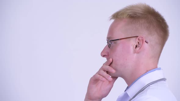 Profile View of Happy Young Blonde Man Doctor Thinking