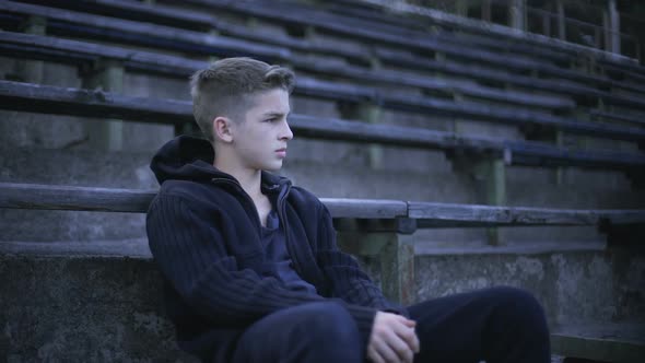 Upset Boy Sitting on Stadium Tribune, Feels Depression, Loneliness and Sorrow