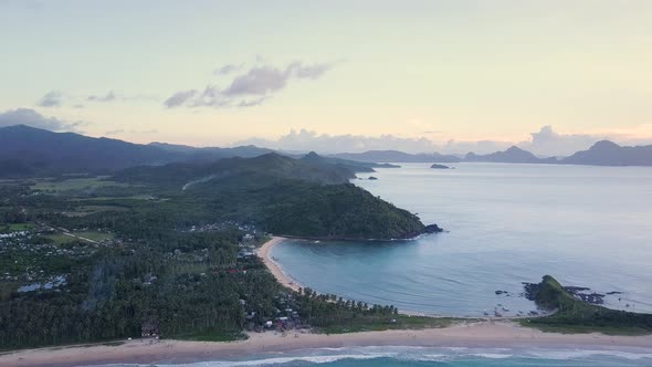 Aerial wide view of Nacpan Beach and Twin Beach at sunset on Palawan, the Philippines camera slightl