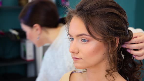 Closeup of the Girl's Face the Hairdresser Puts Her Hair in a Ponytail