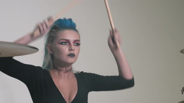 Caucasian Girl with a Deep Neckline Plays the Drums