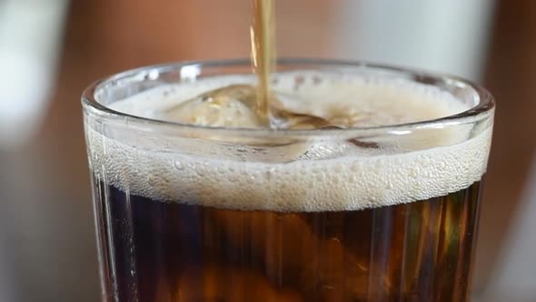 Panning video splash soda drink in the glass on the wooden table