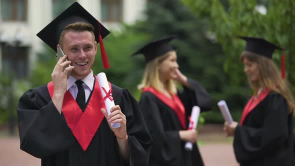 Smiling Student Listening to Greetings on Cellphone and Enjoying Graduation Day