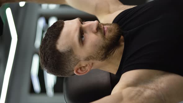Portrait of Muscular Athlete Works Out in a Modern Gym with Dumbbells