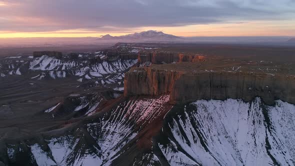 Rising aerial view of rugged desert landscape during sunrise in Utah