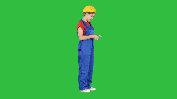 Happy young constructor counting her money on a Green Screen