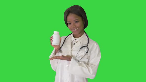 Smiling African American Female Doctor with Stethoscope Advertising Medicine on a Green Screen