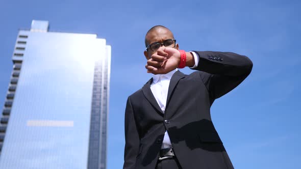 Portrait Of Handsome Businessman Outdoors Looking At His Watch