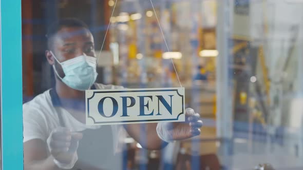 AfricanAmerican Waiter on Mask Turn Closedopen Sign on Coffee Shop Door