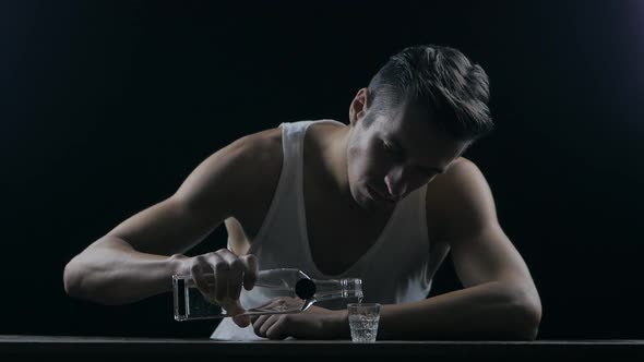 Depressed Man Drinking Vodka in a Dark Room