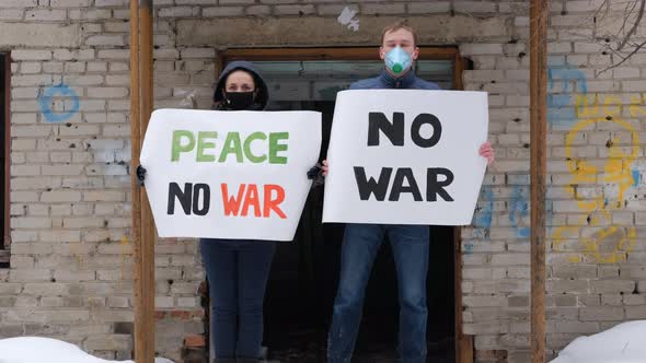 Young Couple Holding Banners Against War