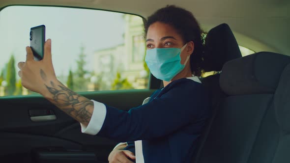 Lovely Woman in Medical Mask Taking Selfie in Car