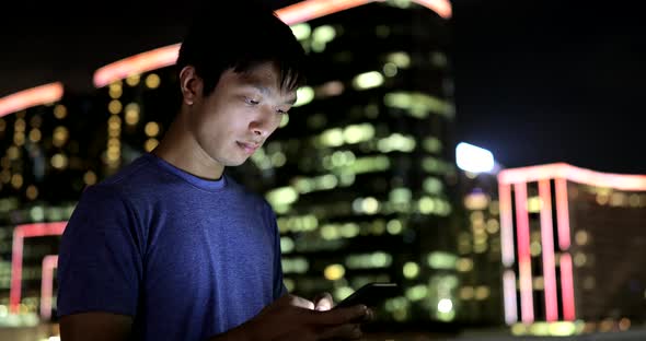 Man use of mobile phone in Hong Kong at night 